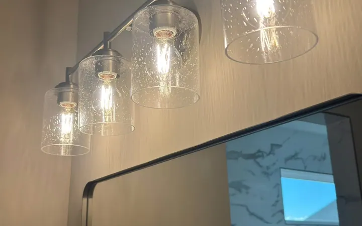 Bathroom vanity light bar with clear glass shades cleaned above a spotless mirror in Middle Tennessee