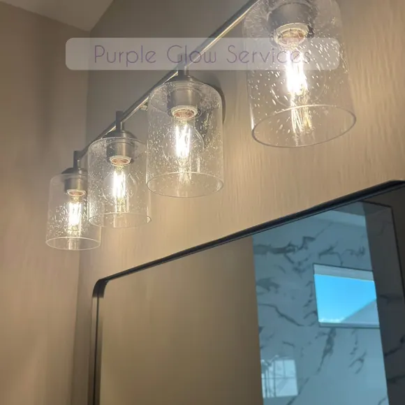 Bathroom vanity light bar with clear glass shades cleaned above a spotless mirror in Middle Tennessee