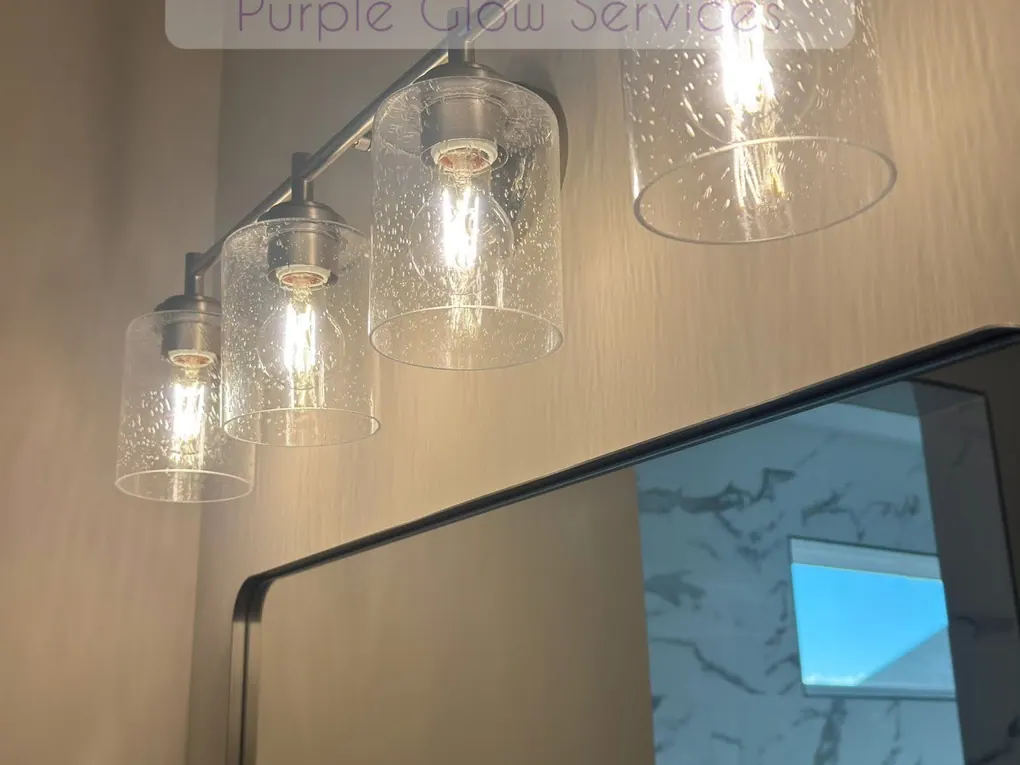 Bathroom vanity light bar with clear glass shades cleaned above a spotless mirror in Middle Tennessee