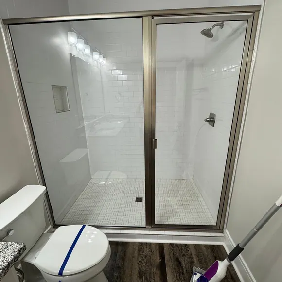 Before and after: a glass shower enclosure cleaned free of soap scum by Purple Glow Services in Murfreesboro, TN