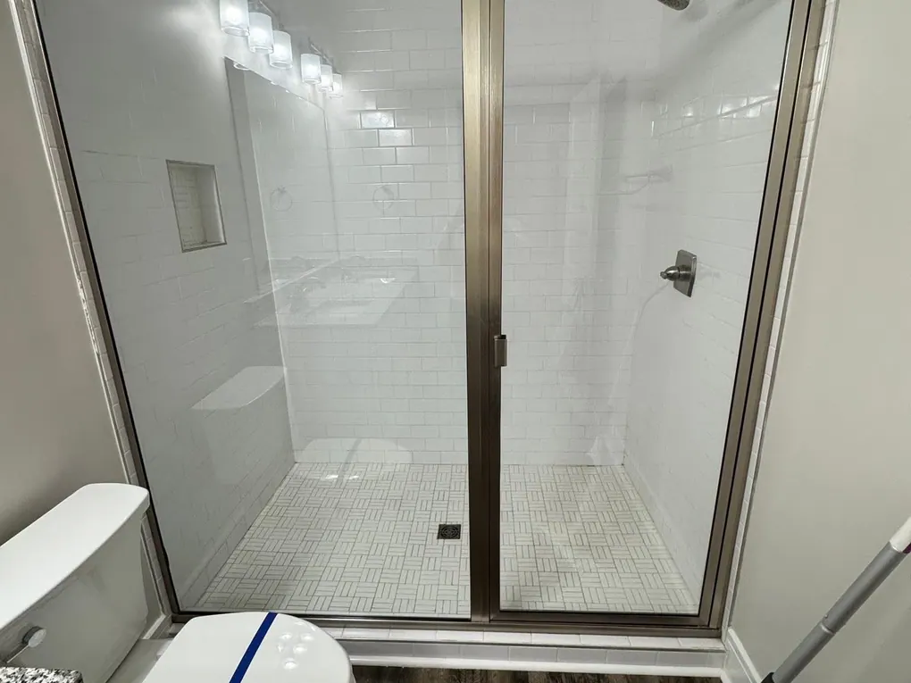 Before and after: a glass shower enclosure cleaned free of soap scum by Purple Glow Services in Murfreesboro, TN