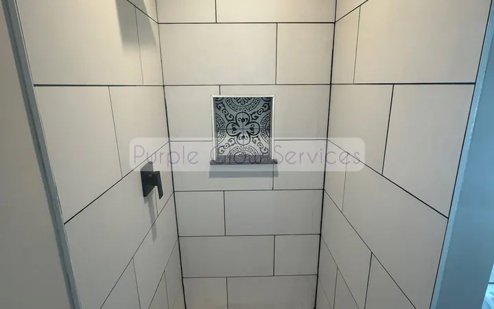 Freshly cleaned tiled walk-in shower with a hex tile floor and built-in niche in Murfreesboro, TN