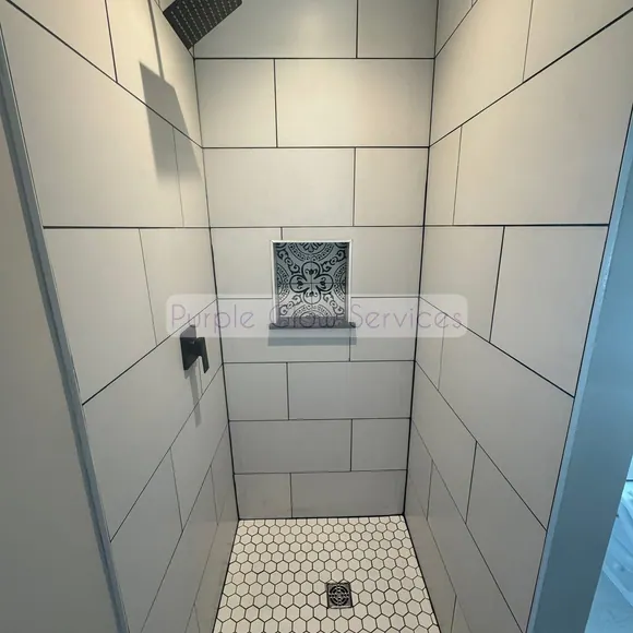 Freshly cleaned tiled walk-in shower with a hex tile floor and built-in niche in Murfreesboro, TN