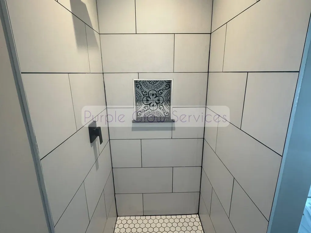 Freshly cleaned tiled walk-in shower with a hex tile floor and built-in niche in Murfreesboro, TN